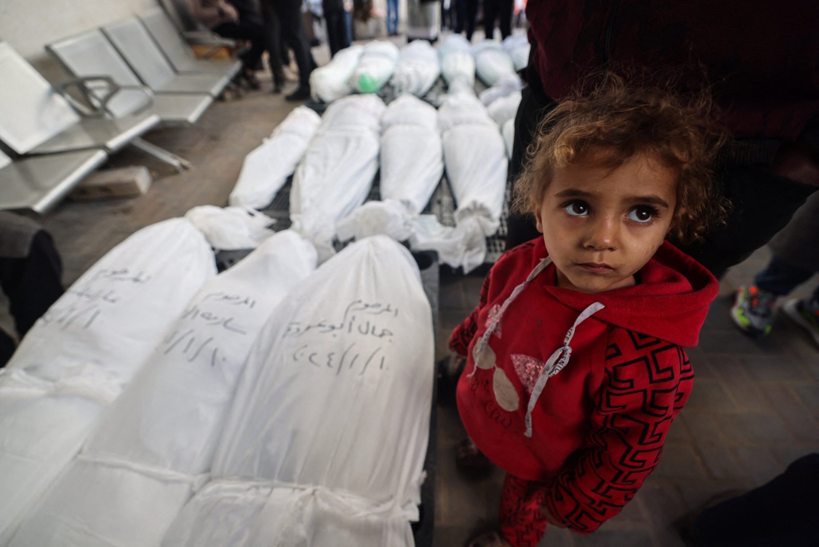 EDITORS NOTE: Graphic content / A child stands near the bodies of family members of "Ayman Nofal, or "Abu Ahmad", a member of the Hamas general military council and commander of the central command in Al-Qassam Brigades, after they were killed the previous day during Israeli bombardment, on January 10, 2024 at al Najar hospital in Rafah in the Gaza Strip. (Photo by AFP)
