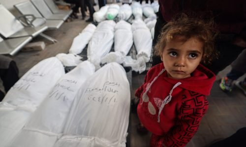 EDITORS NOTE: Graphic content / A child stands near the bodies of family members of "Ayman Nofal, or "Abu Ahmad", a member of the Hamas general military council and commander of the central command in Al-Qassam Brigades, after they were killed the previous day during Israeli bombardment, on January 10, 2024 at al Najar hospital in Rafah in the Gaza Strip. (Photo by AFP)