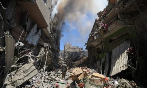 Smoke rises as a Palestinian man inspects the site of Israeli strikes on buildings at Gaza's Old City market, in Gaza City July 9, 2025. REUTERS/Dawoud Abu Alkas     TPX IMAGES OF THE DAY